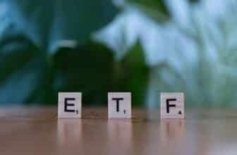 A wooden block spelling the word etf on a table